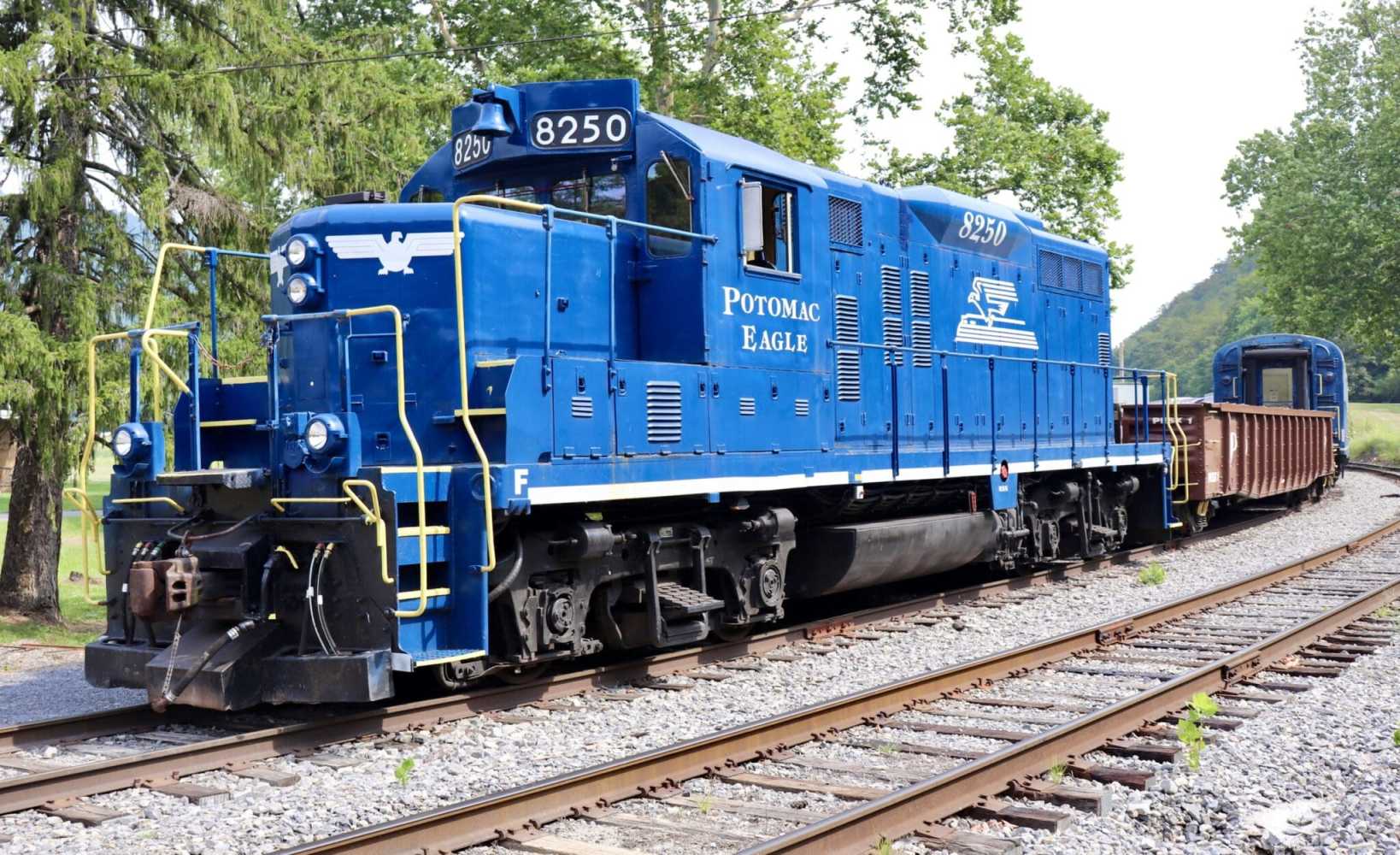 a blue train traveling down train tracks