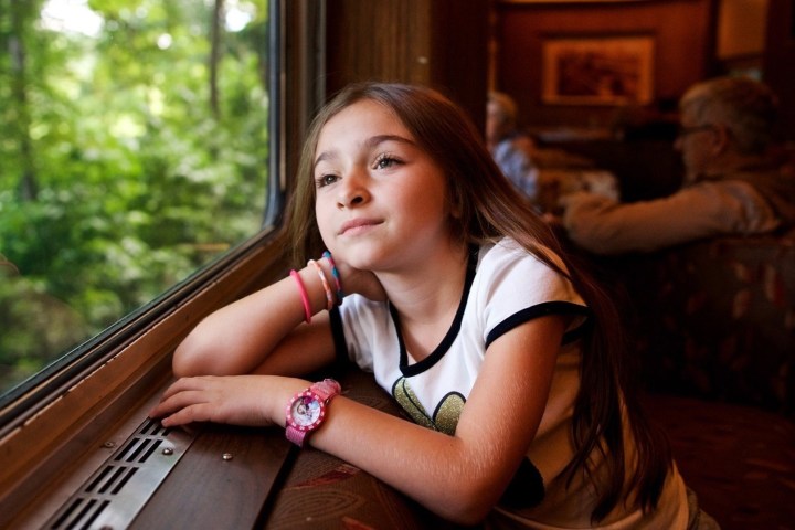 Little girl looking out her train car window