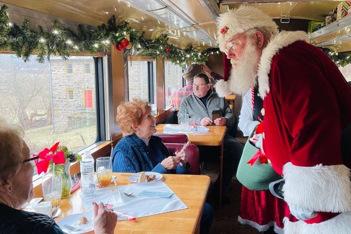 a group of people sitting at a table with a cake