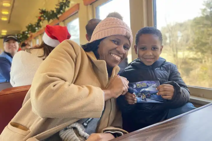 Mother and Son holding the North Pole Express ticket during the Christmas train ride