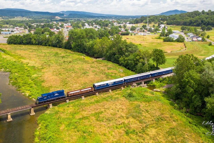 a train traveling through a lush green field outside of Petersburg, WV