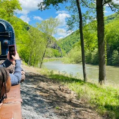 A woman taking pictures of the river from the gondola car