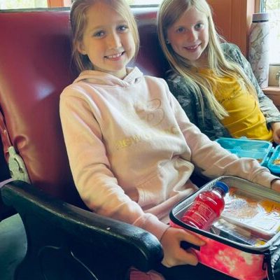 Two young girls enjoying their lunch in Standard Coach