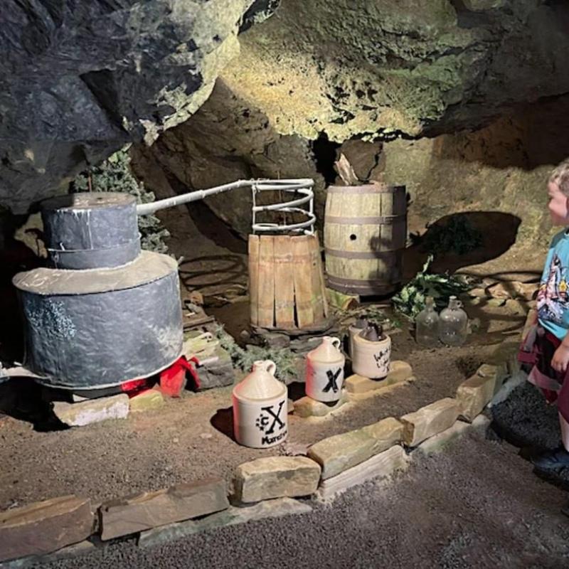 a person standing next to a rock wall